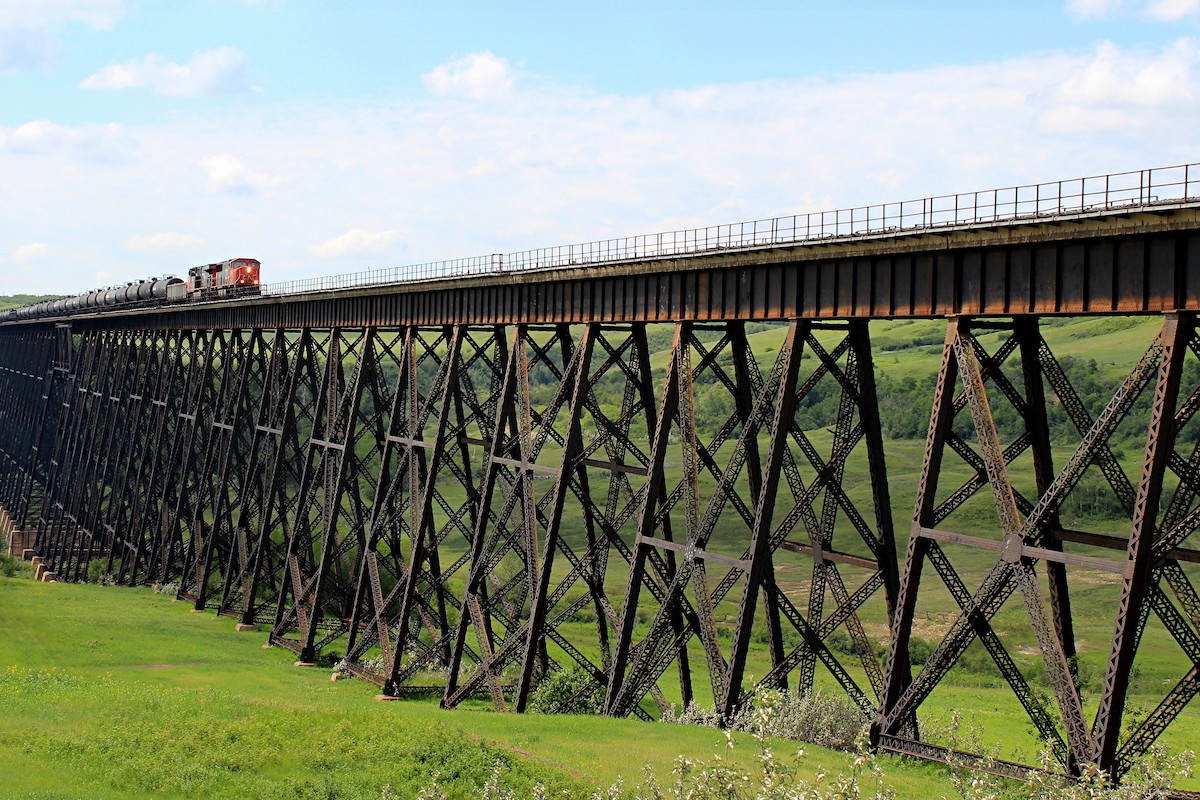 Battle River Railway Trestle, also known as the Fabyan Trestle Bridge, with a train moving towards the camera and green grass below
