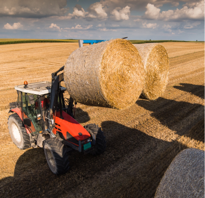 a hay baler in a field in Alberta creating two bales of hay