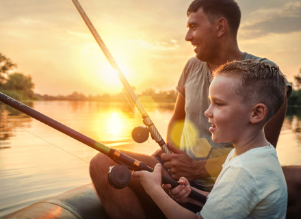 battle river region healthy lifestyle represented by a man and his son smiling while fishing at a lake with the sun setting in the distance