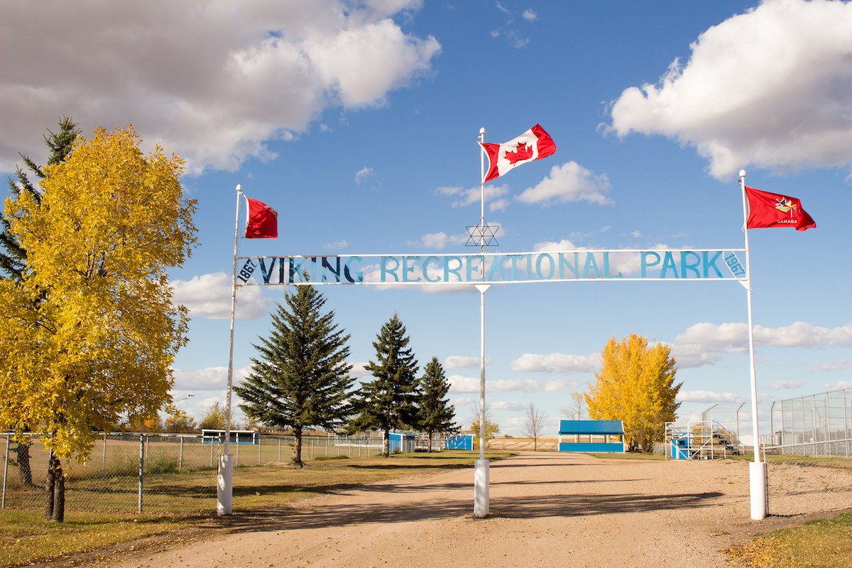 three flags in the town of viking in alberta with the canadian flag in the centre