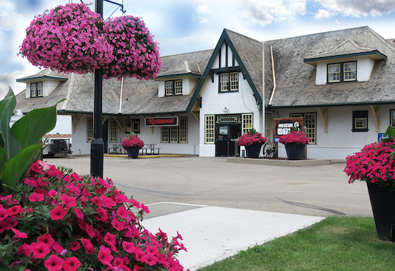local alberta business wainright restaurant european-style front exterior with hanging baskets and flower pots of bright pink petunias